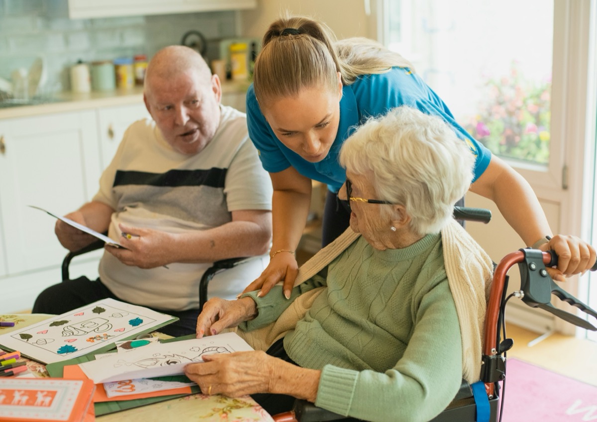 A support worker helping elderly clients at home