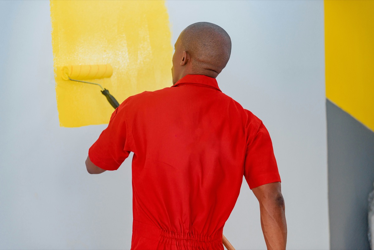 A painter rolling fresh paint onto a wall