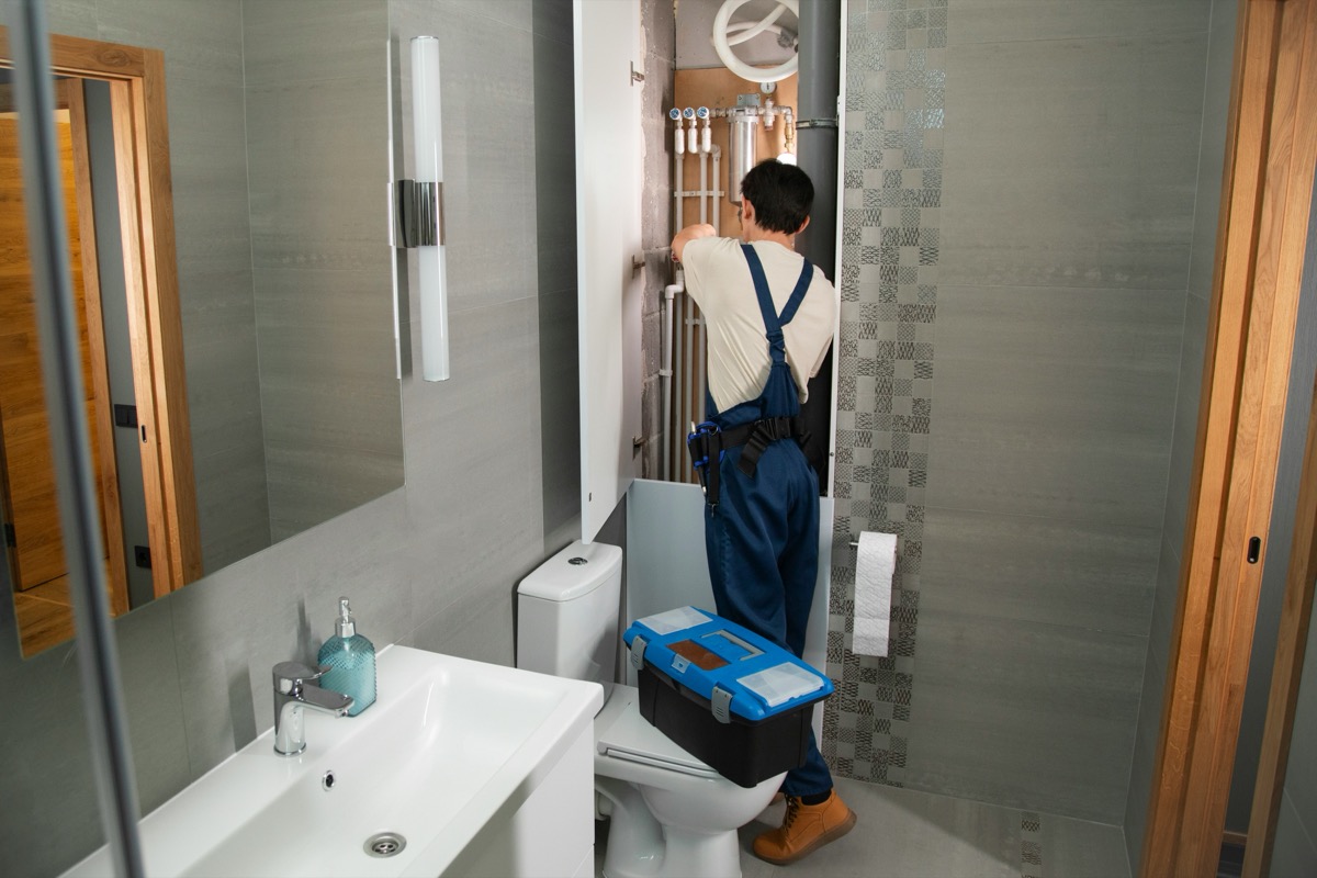 A plumber working on bathroom plumbing